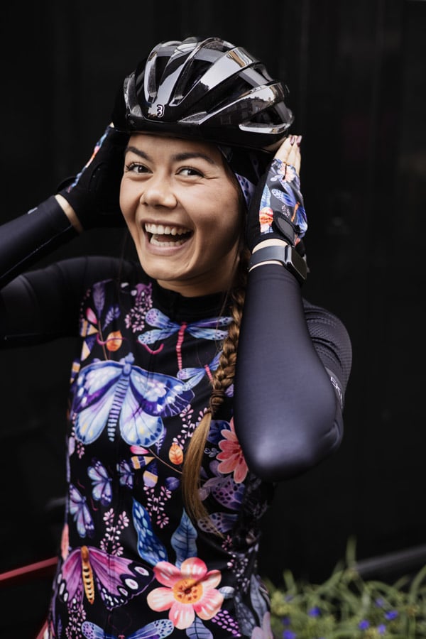 dames wieleroutfit met zwart-paarse bloemen en vlinders